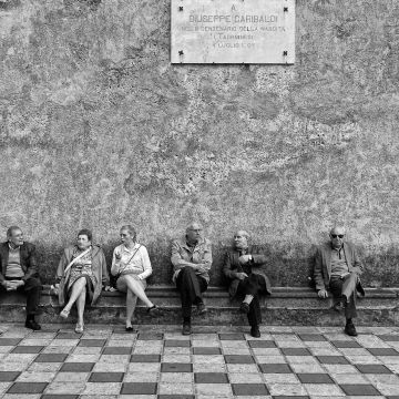 Italiener sitzen auf einer langen Steinbank