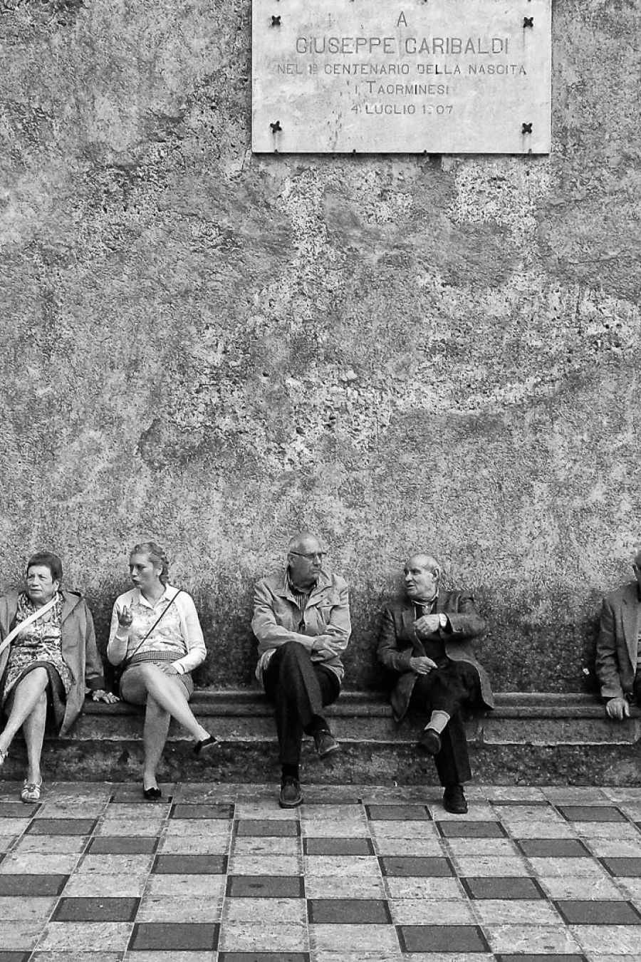 Italiener sitzen auf ein Bank in Schwarz-Weiss fotografiert.