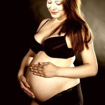 Glückliche Mutter blickt auf Ihren Babybauch