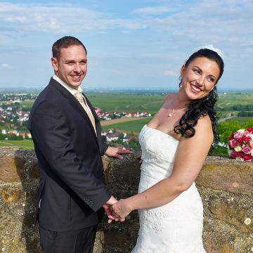 Brautpaar blickt bei strahlendem Sonnenschein von der Burg Neuleiningen auf die Rheinebene