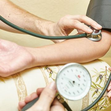 Klassische Blutdruckmessung mit einem mechanischen Sphygmomanometer und Stethoskop