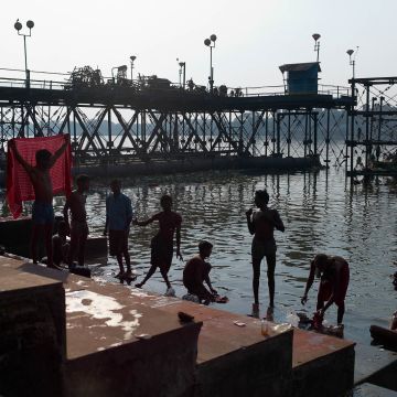Badende Jugendliche am Ganges im Gegenlicht