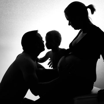 Junge Familie im Scherenschnitt. Mutter mit Babybauch