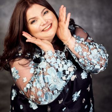 Curvy Model mit Handpose am Gesicht