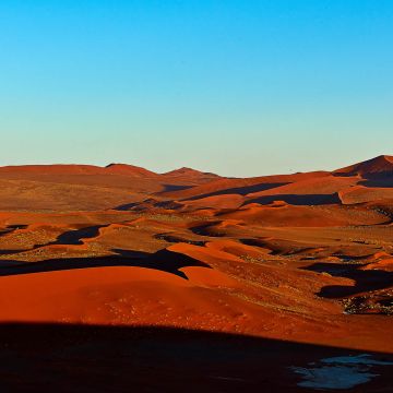 Sanddünen im roten Morgenlicht der aufgehenden Sonne